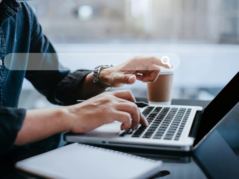 Business man clicking internet search page on computer touch screen at home office.